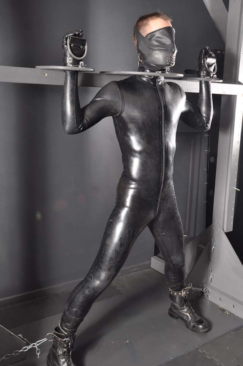 Standing bondage in rubber.